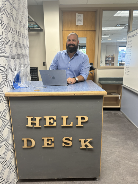 Joe Sumpter sitting at the help desk.